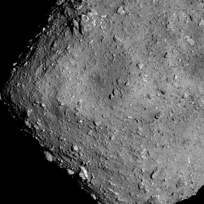 close-up of rocky surface of grey asteroid.