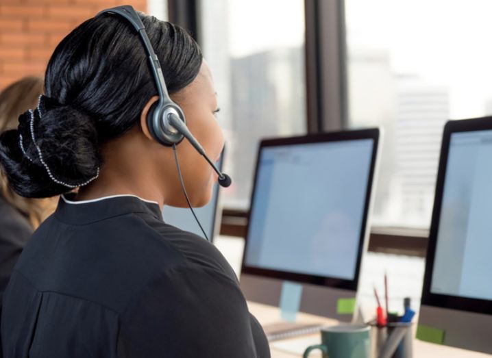 Call centre worker wearing a headset at a computer.