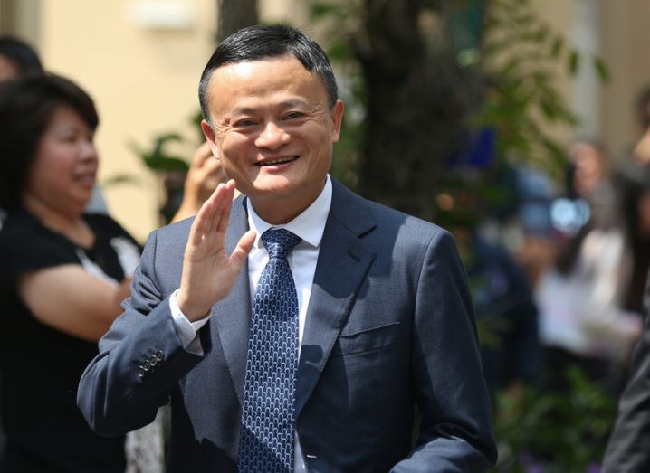 Alibaba chair Jack Ma, smiling and waving, wearing a suit.