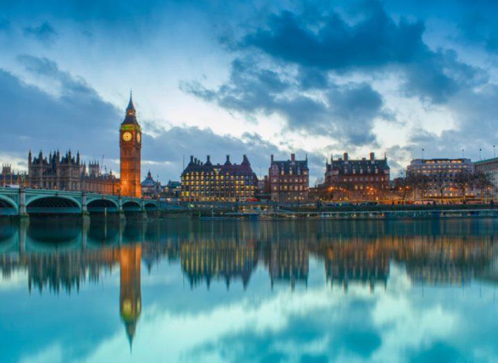 UK Houses of Parliament at sunset, reflected in the River Thames, London.