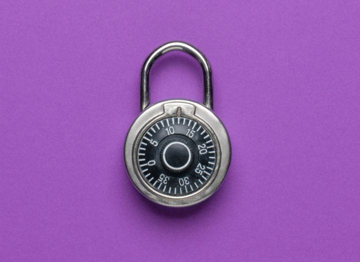 A black combination lock resting on a rich purple background.