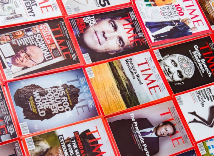 Numerous issues of Time Magazine spread out on a flat surface.