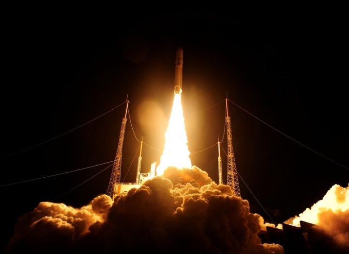 The Ariane 5 rocket taking off at night time, releasing a bright, orange flame.