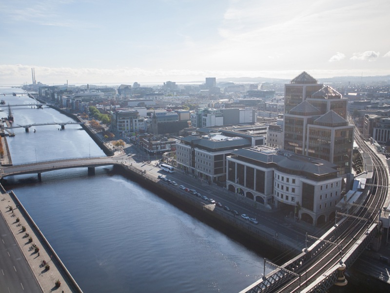 Aerial view of Dublin's Liffey with a train track running across bridge.