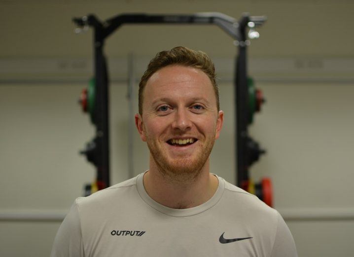 Dr Martin O'Reilly, smiling, in front of gym equipment.