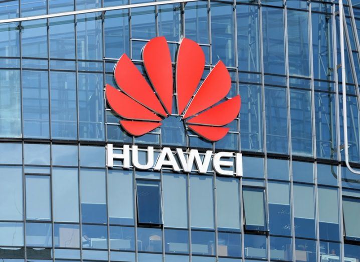 Huawei logo on the side of a glass skyscraper.