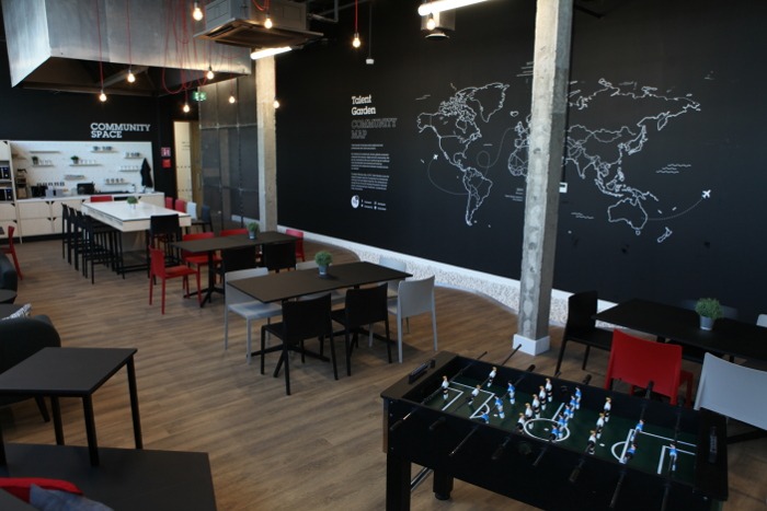 A common area in Talent Garden with a map outline on a wall and table football in the foreground.