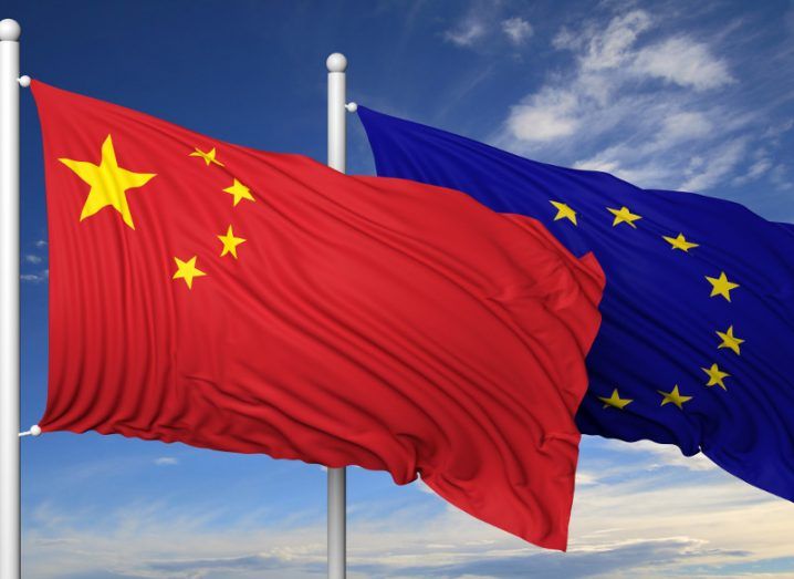 China flag alongside an EU flag under a blue cloudy sky.