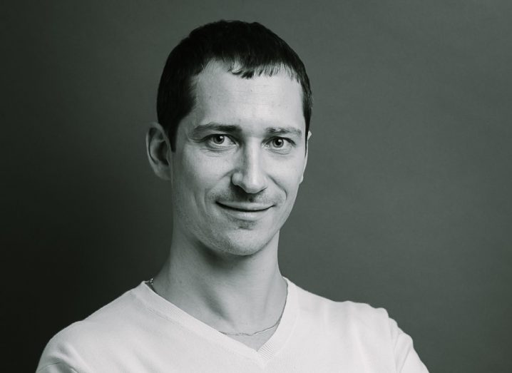 Dark-haired man in white v-necked t-shirt. Black and white photo.