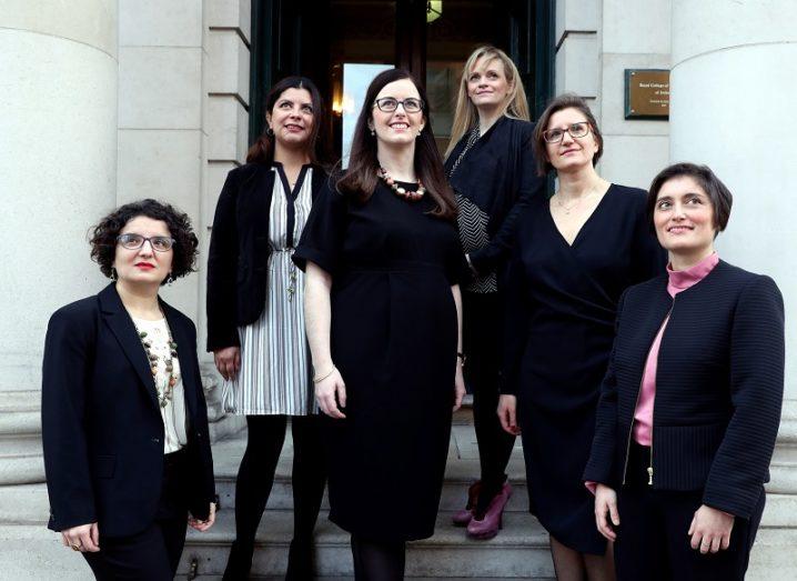 The six women researchers funded under SIRG standing and smiling on a set of steps.