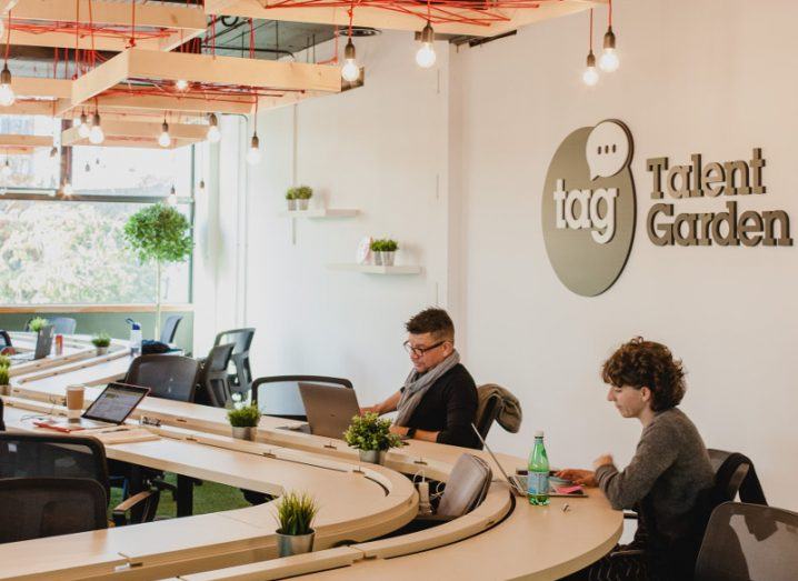 People at work around a swirl-shaped table at Talent Garden in Dublin.