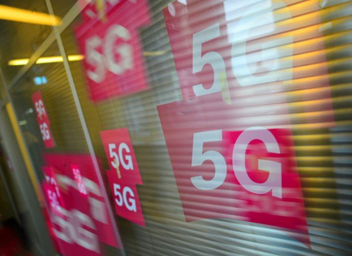 Images of 5G cards on a window in Deutsche Telekom pink branding.