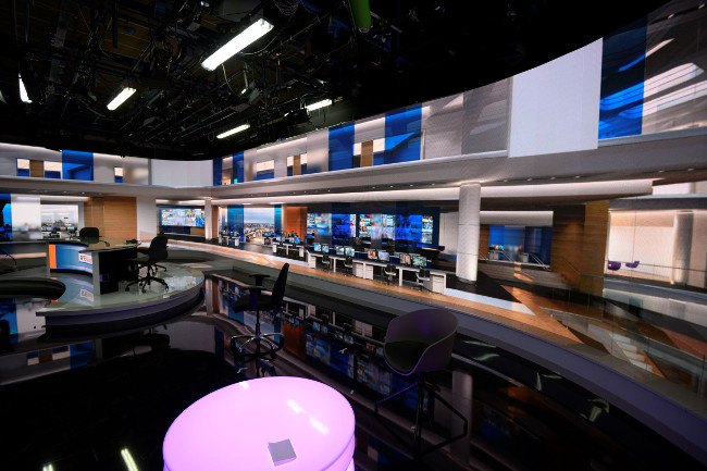 A view of the new RTE studio showing big display panels and lights with a pink neon table.