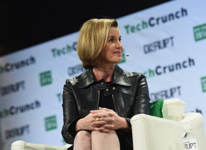 Woman with brown/blonde hair sits on a cream sofa on stage at a TechCrunch event in New York.