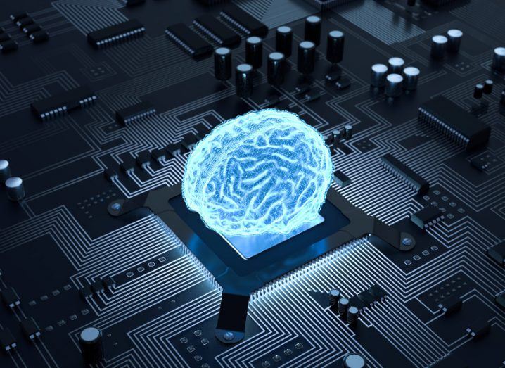 Image of a blue fluorescent brain on top of a CPU on a computer circuit board.