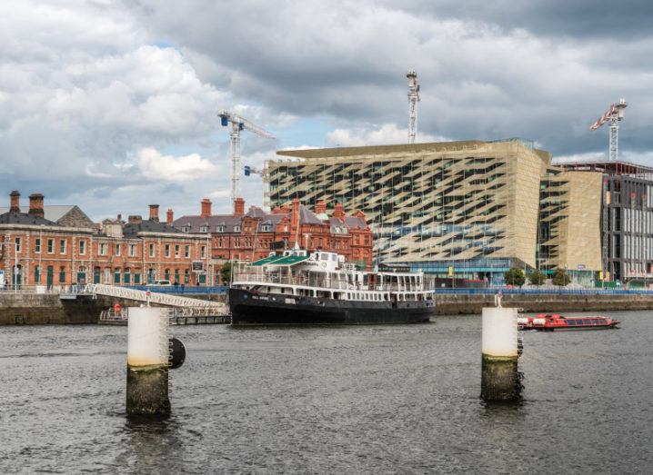 Central Bank of Ireland on Dublin's quays with old buildings and a boat in front of it.