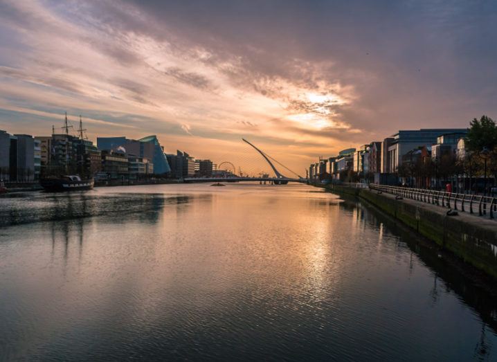 Dawn breaks over Ireland's financial district in the Dublin docklands with sun glinting off River Liffey.