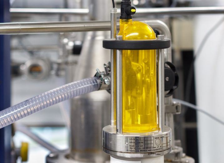 Yellow liquid held in a clear tubing system surrounded by industrial equipment.