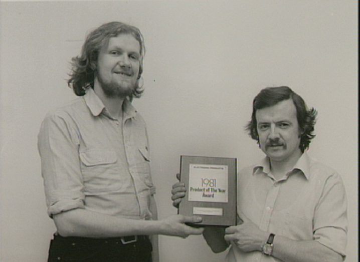 Black and white image of Mike Tuthill receiving an award for a product of the year in 1981.