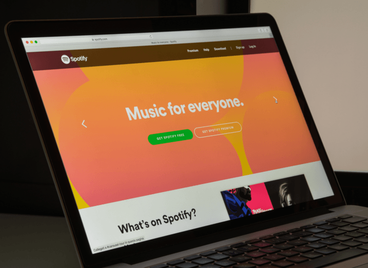 Spotify's orange homepage displayed on a laptop screen.