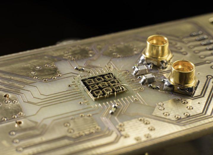 Thin aluminium wires connect the surface of a quantum semiconductor chip to pads on a circuit board.