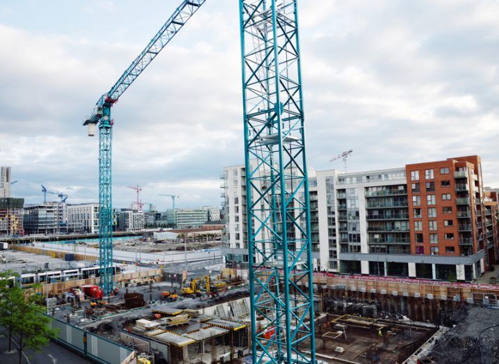 A construction site in Dublin’s docklands with a view of the city and multiple cranes dotting the skyline.