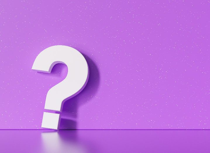 Rendering of a large, three-dimensional white question mark leaning against a speckled purple wall.