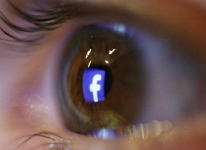 Close-up of an eye with the Facebook logo in it.