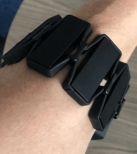 The ISL translator wristband coloured black with a number of sensors on a person's arm.