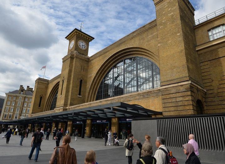 Exterior of King's Cross Station with people walking past.