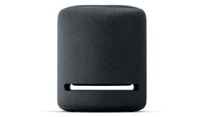 A squat cylindrical speaker covered in a charcoal mesh with a an open slit near the base.