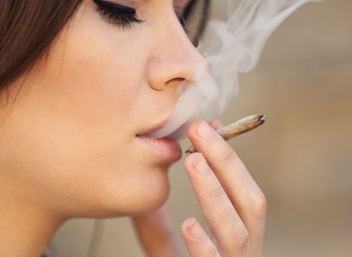 Close-up of a woman smoking a cannabis cigarette.