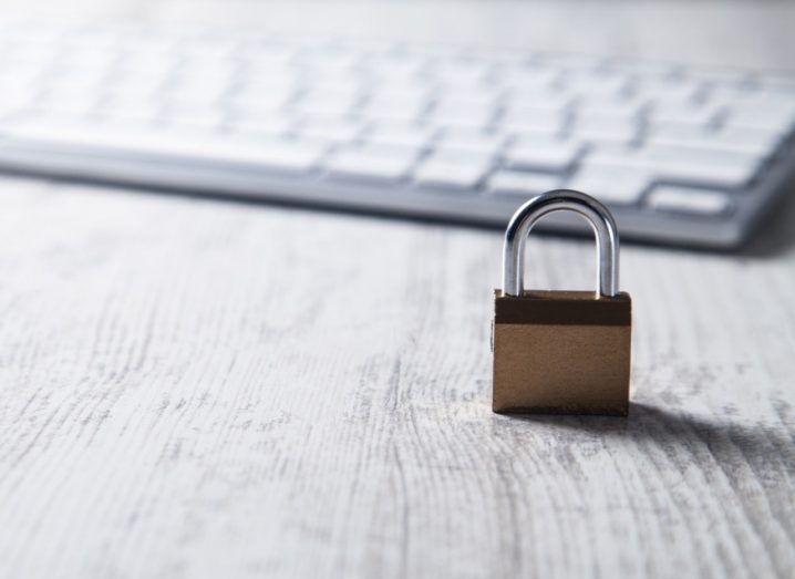 Padlock with computer keyboard in background symbolising cybersecurity.