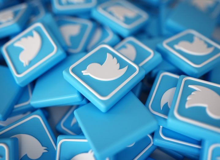 Pile of 3D blue Twitter logos with white birds on them.