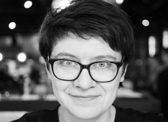 Black and white headshot of Dr Tanya Lokot wearing glasses.