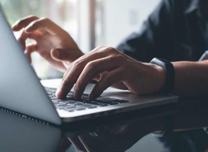 A close-up shot of hands typing on a laptop, representing the need to have avoid a data breach.