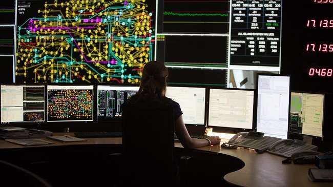 Simulation of EirGrid's national grid control centre with a person monitoring multiple screens.