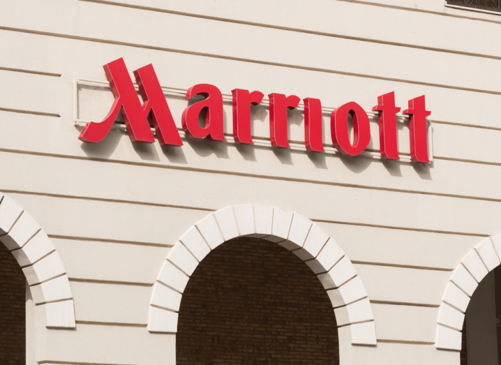 The red Marriott hotel logo on a white, panelled wall over arches.