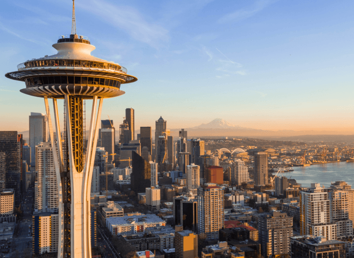 Skyscrapers in Seattle beside a body of water, under a blue sky.