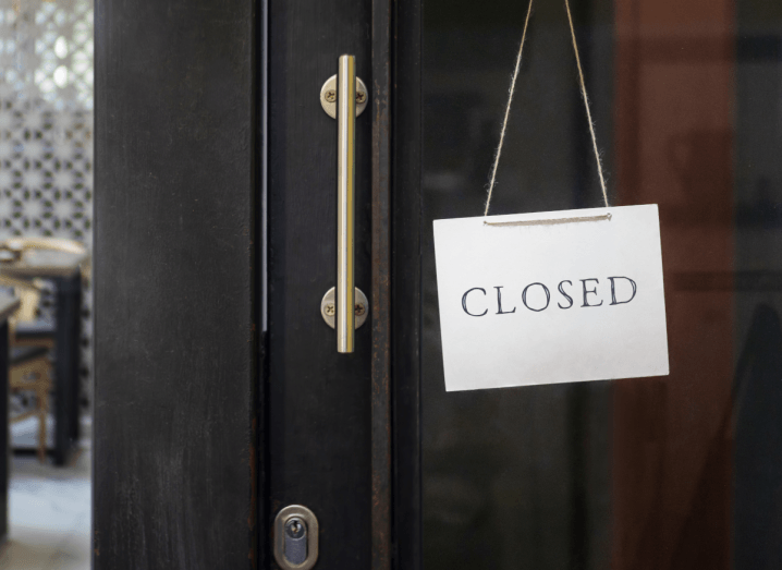 A business with a sign on the door saying it is closed.