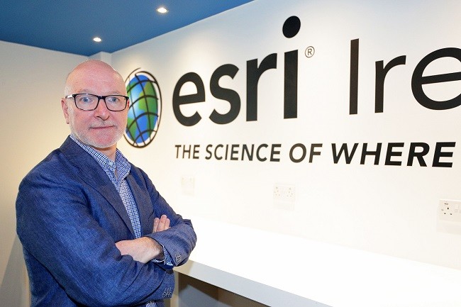 Eamonn Doyle in a blue blazer crossing his arms in front of the Esri Ireland logo.