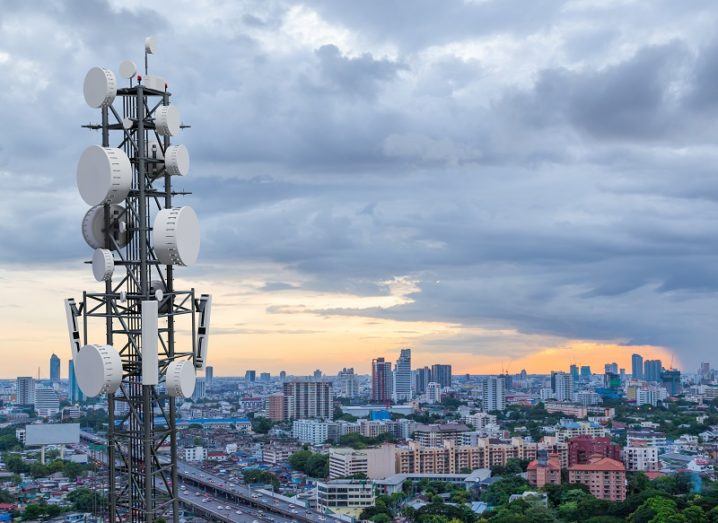 Telecoms tower overlooking a cityscape at dusk.