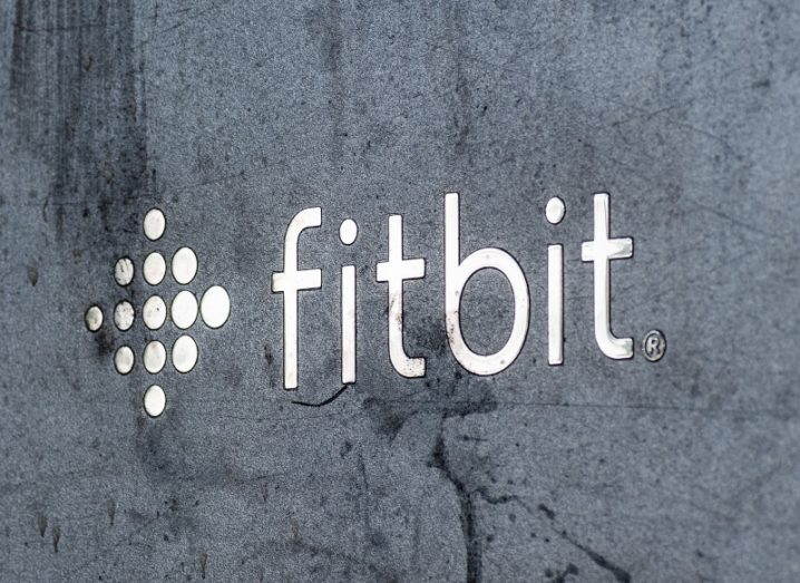 The Fitbit logo emblazoned on a grey stone wall.