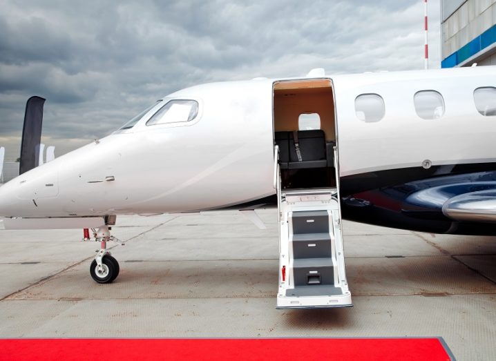 Door and footladder open on a parked private jet at an airport.