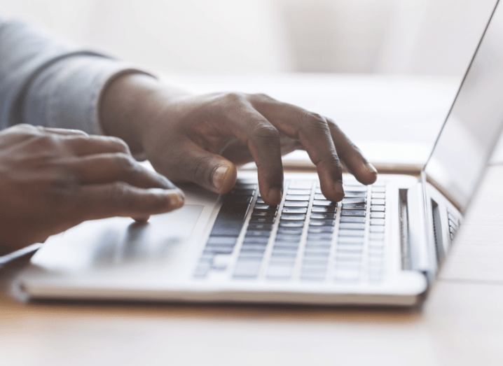 Hands typing on a laptop keyboard.