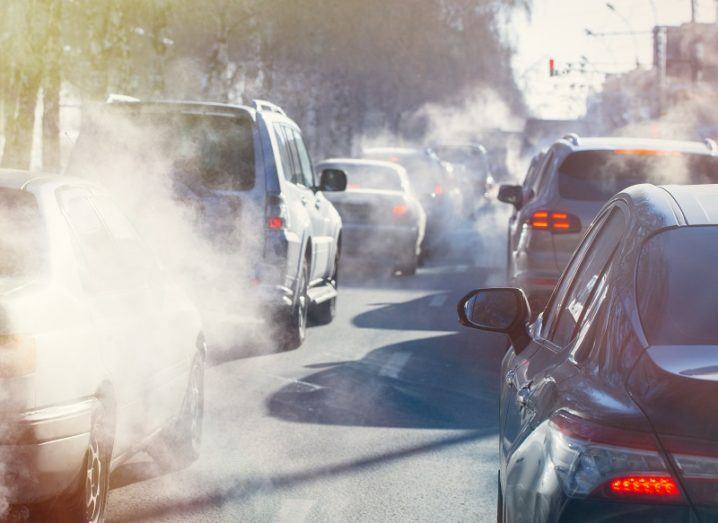 Cars waiting in traffic releasing emissions from exhausts.