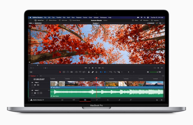 An open MacBook Pro showing video editing software on the screen.