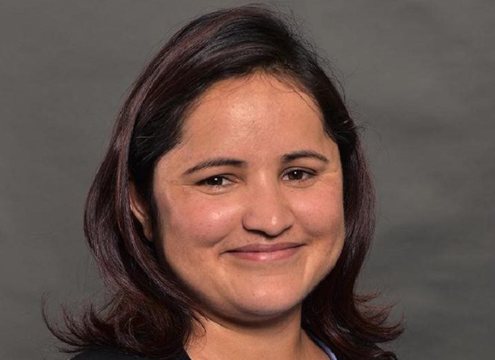 Headshot of Dr Sita Karki smiling against a grey background.