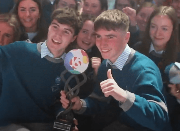 Cormac Harris and Alan O’Sullivan holding their BTYSTE 2020 trophy surrounded by students.