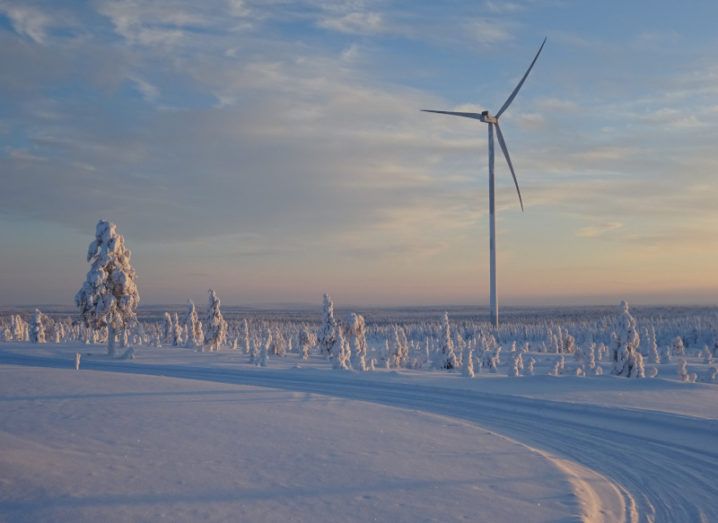 A wind turbine is standing in the middle of a snowy landscape.